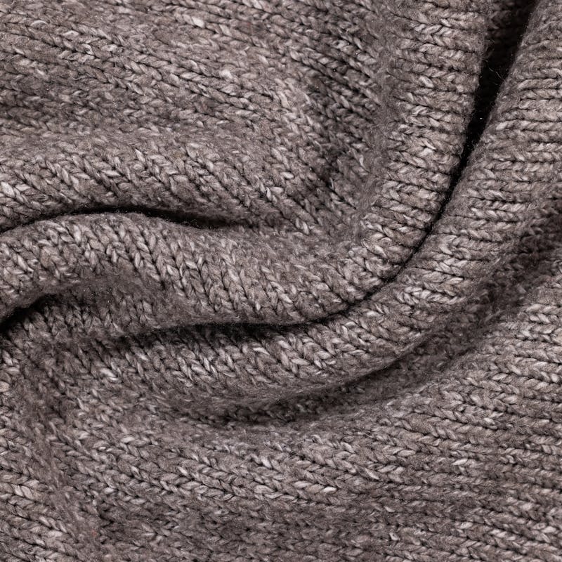 Detailed close-up of a gray knitted textile, showing the fabric's texture and weave pattern.
