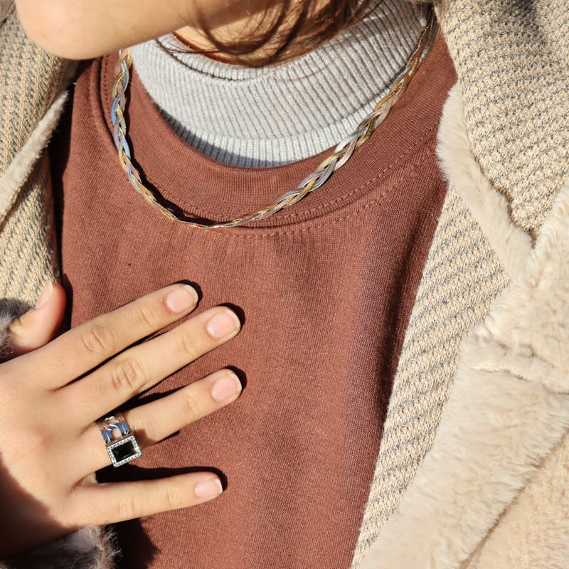Detailed view of a fur coat with ring, necklace, and stylish accessories, perfect for winter fashion.